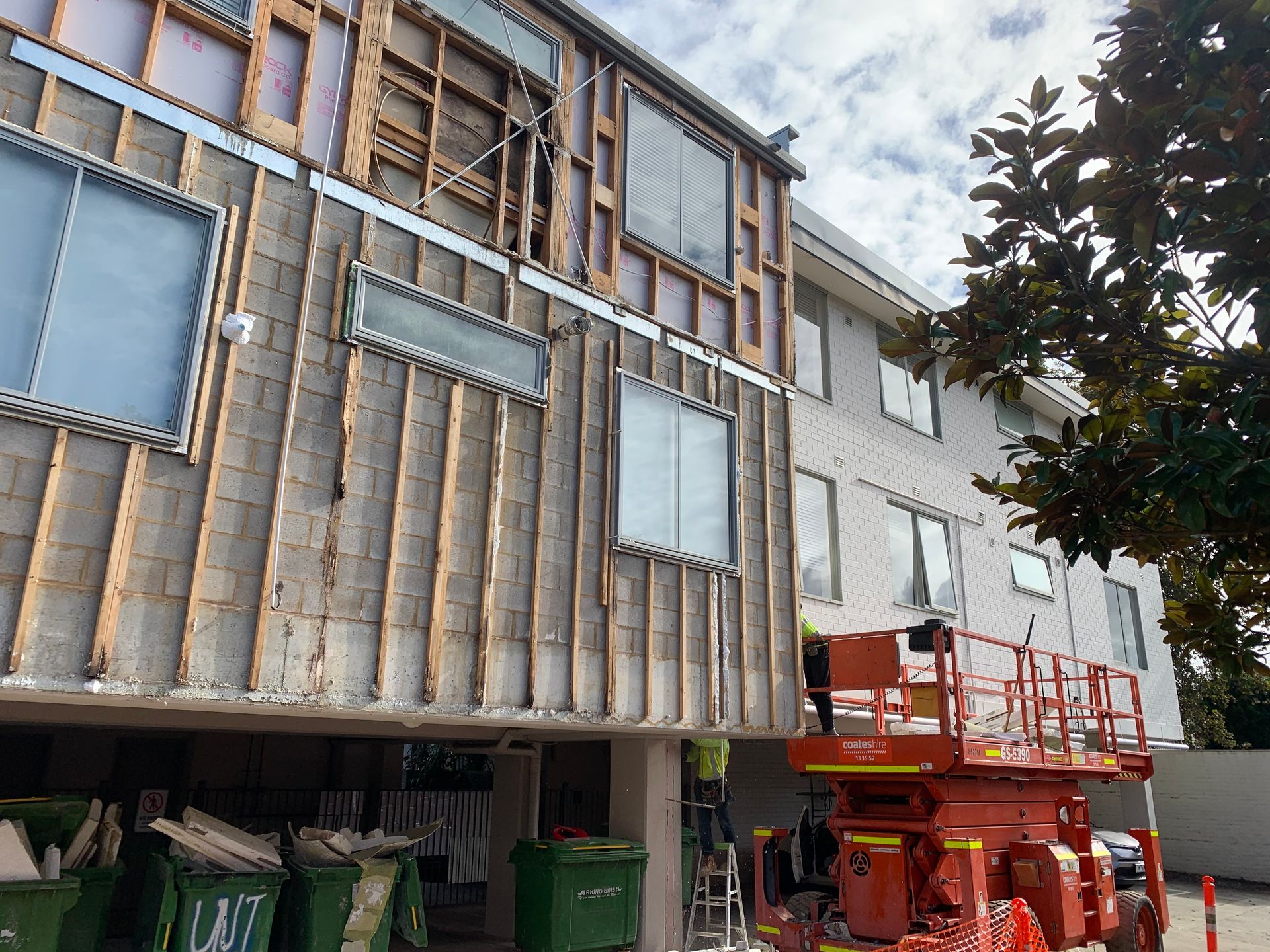 A large building with a lot of windows is being remodeled.