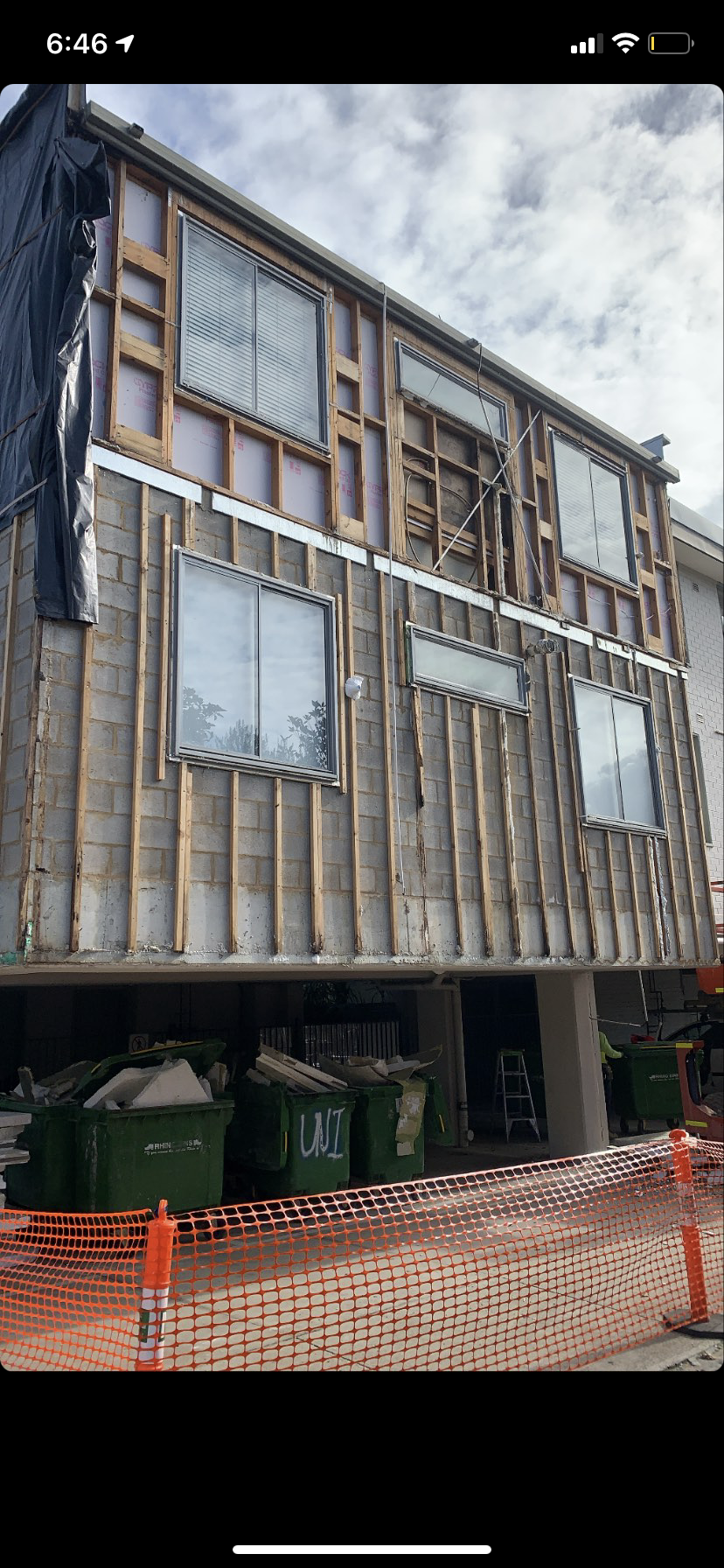 A building under construction with a lot of windows and a fence around it.