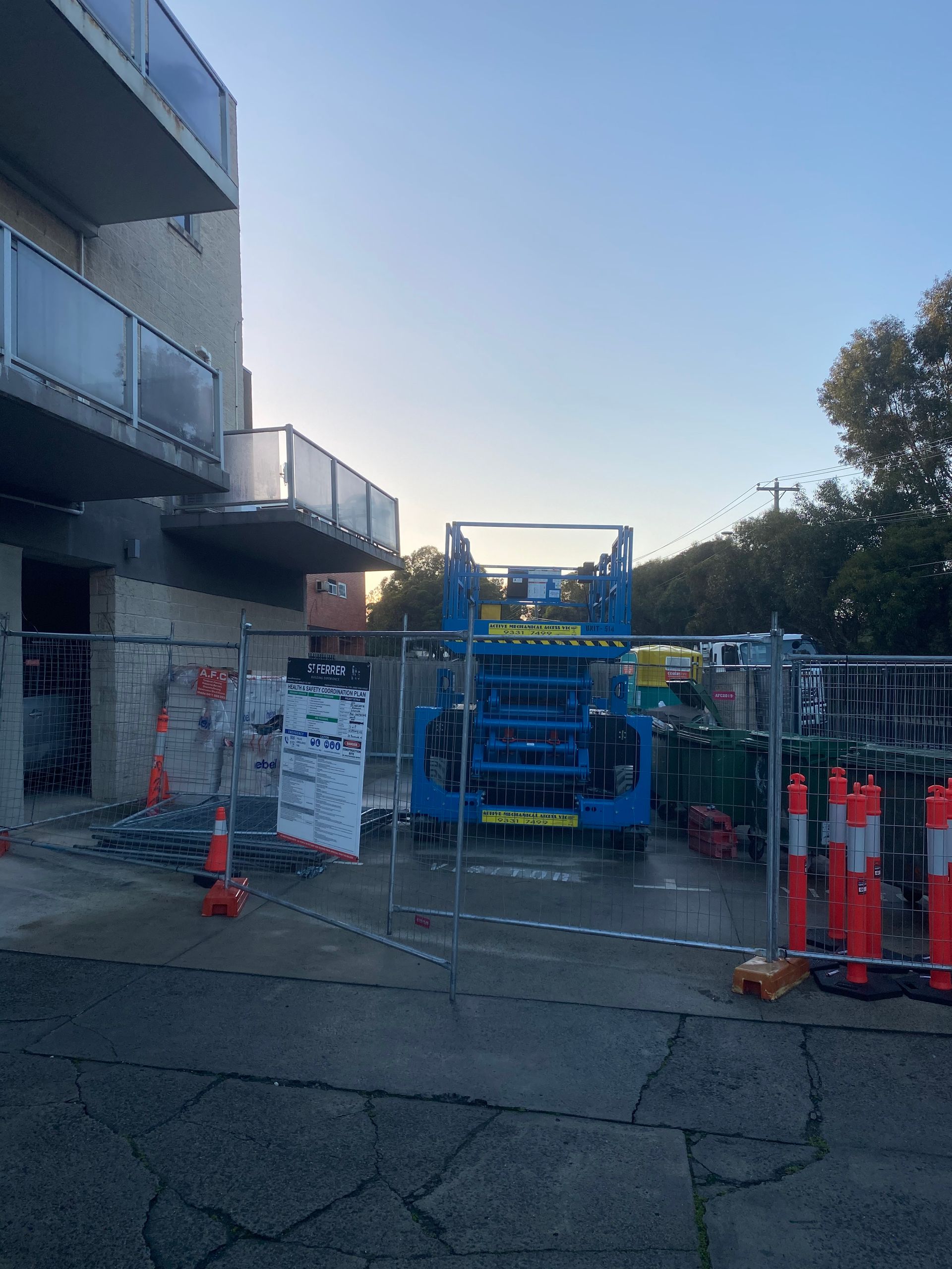 A construction site with a fence and orange cones