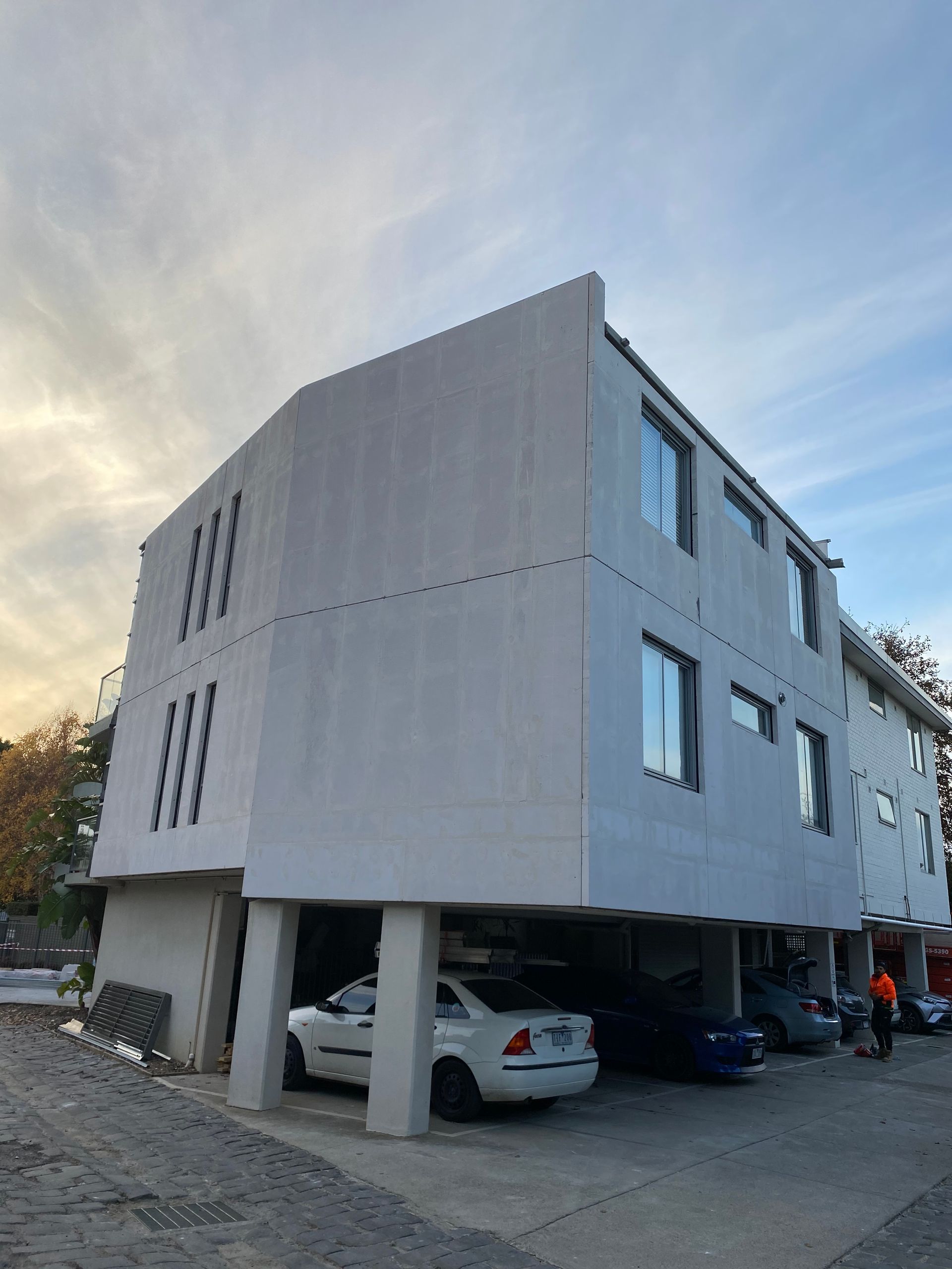 A white car is parked in front of a building
