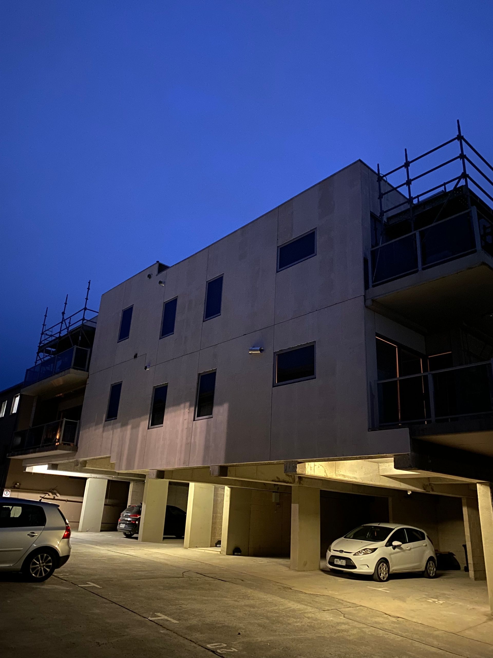 A building with cars parked in front of it at night