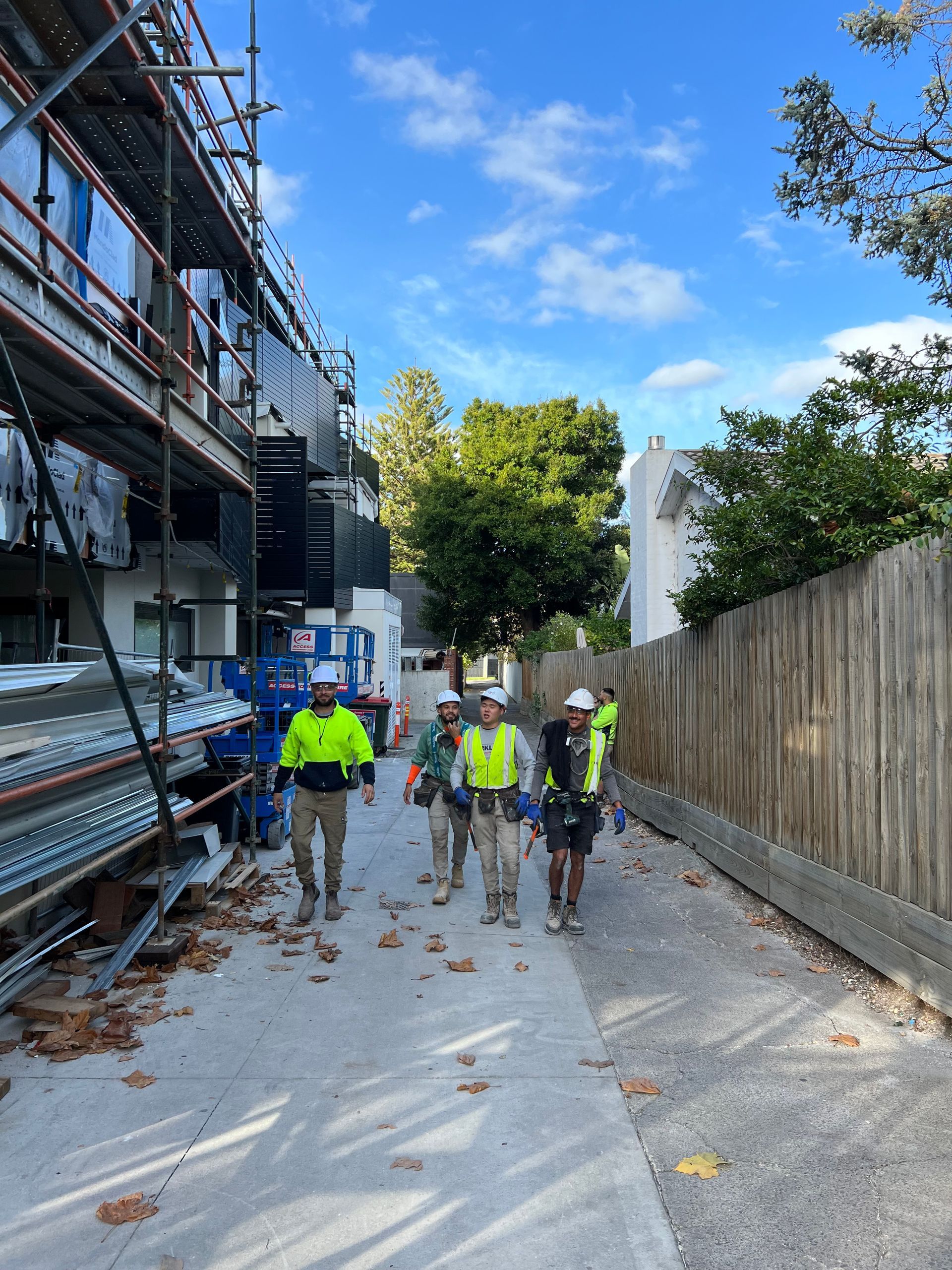 A group of construction workers are walking down a sidewalk