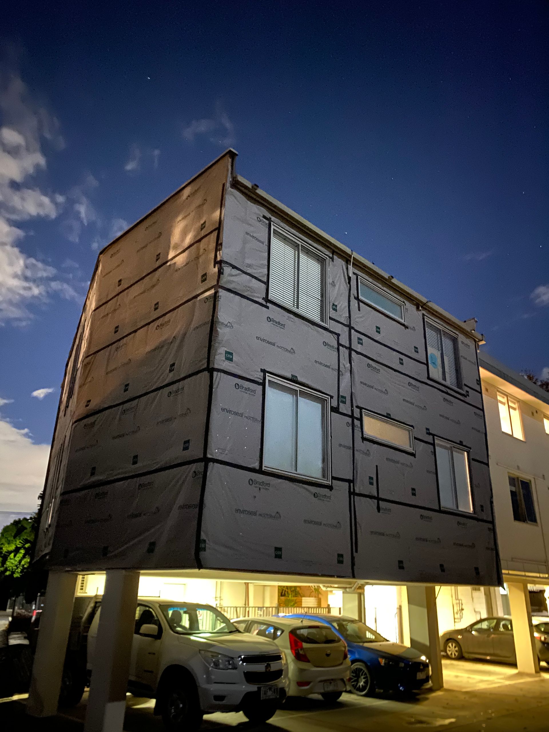 A building with cars parked in front of it at night