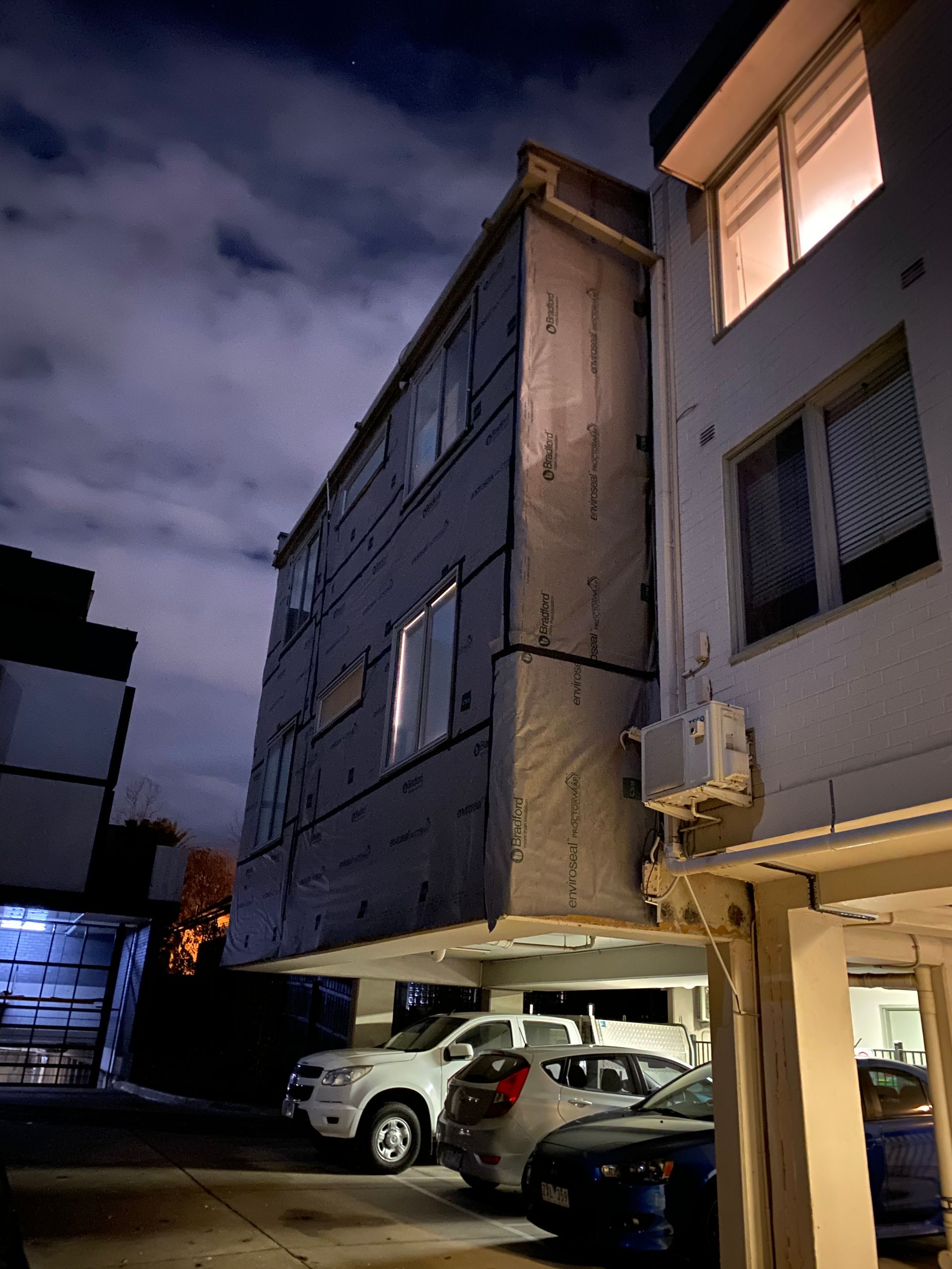 A building with cars parked in front of it at night