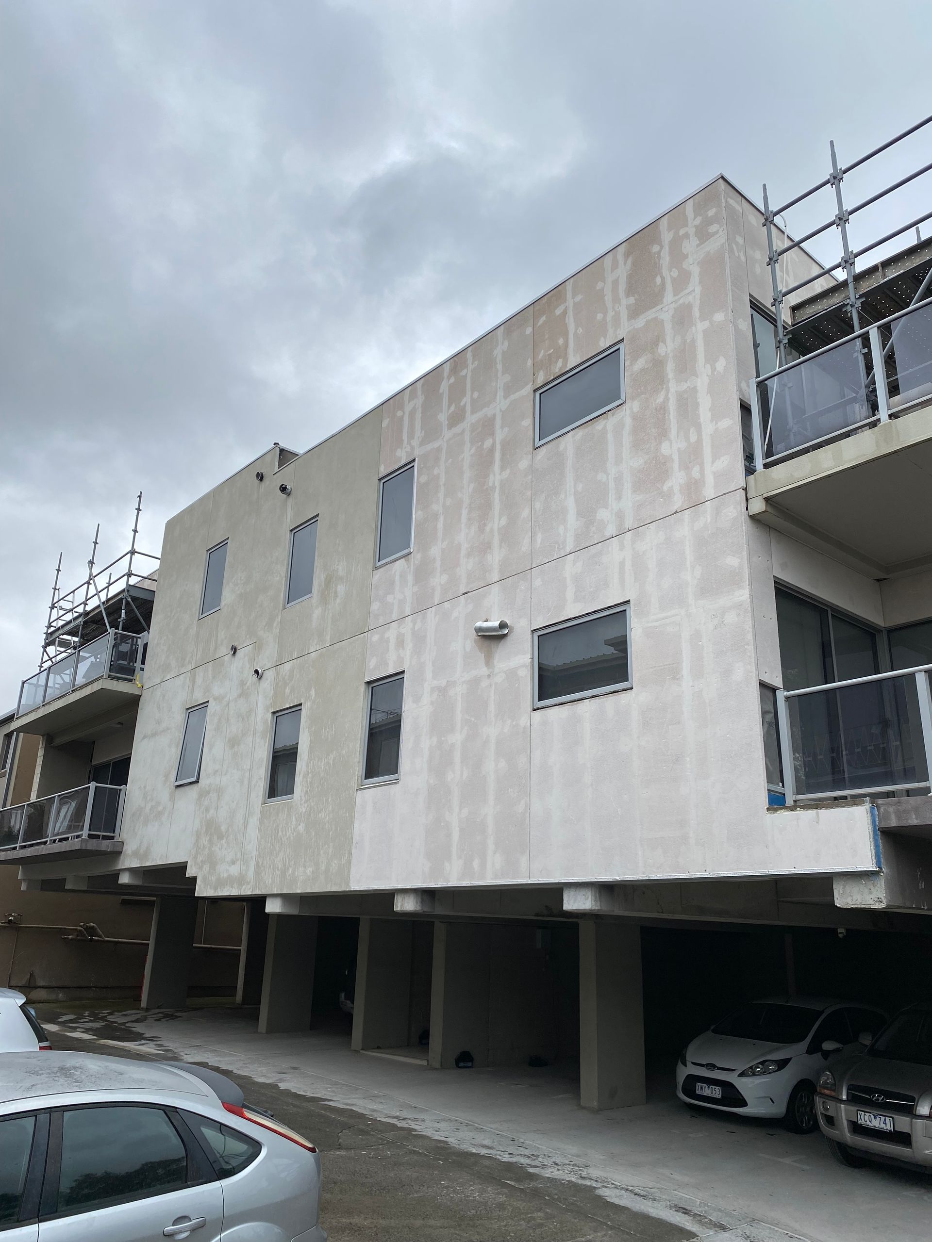 A building with a lot of windows and cars parked in front of it.