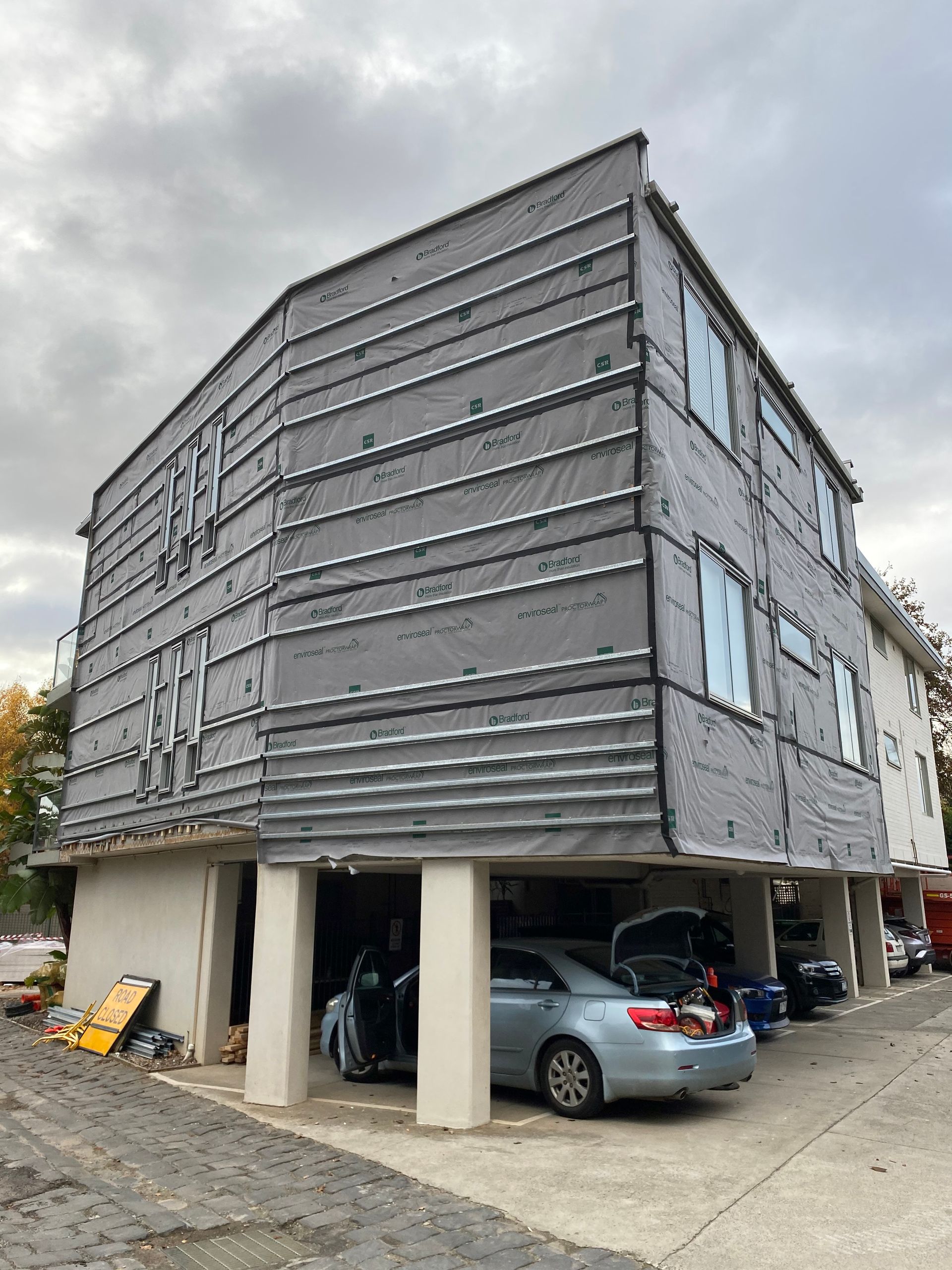 A building with a lot of windows and a car parked in front of it.