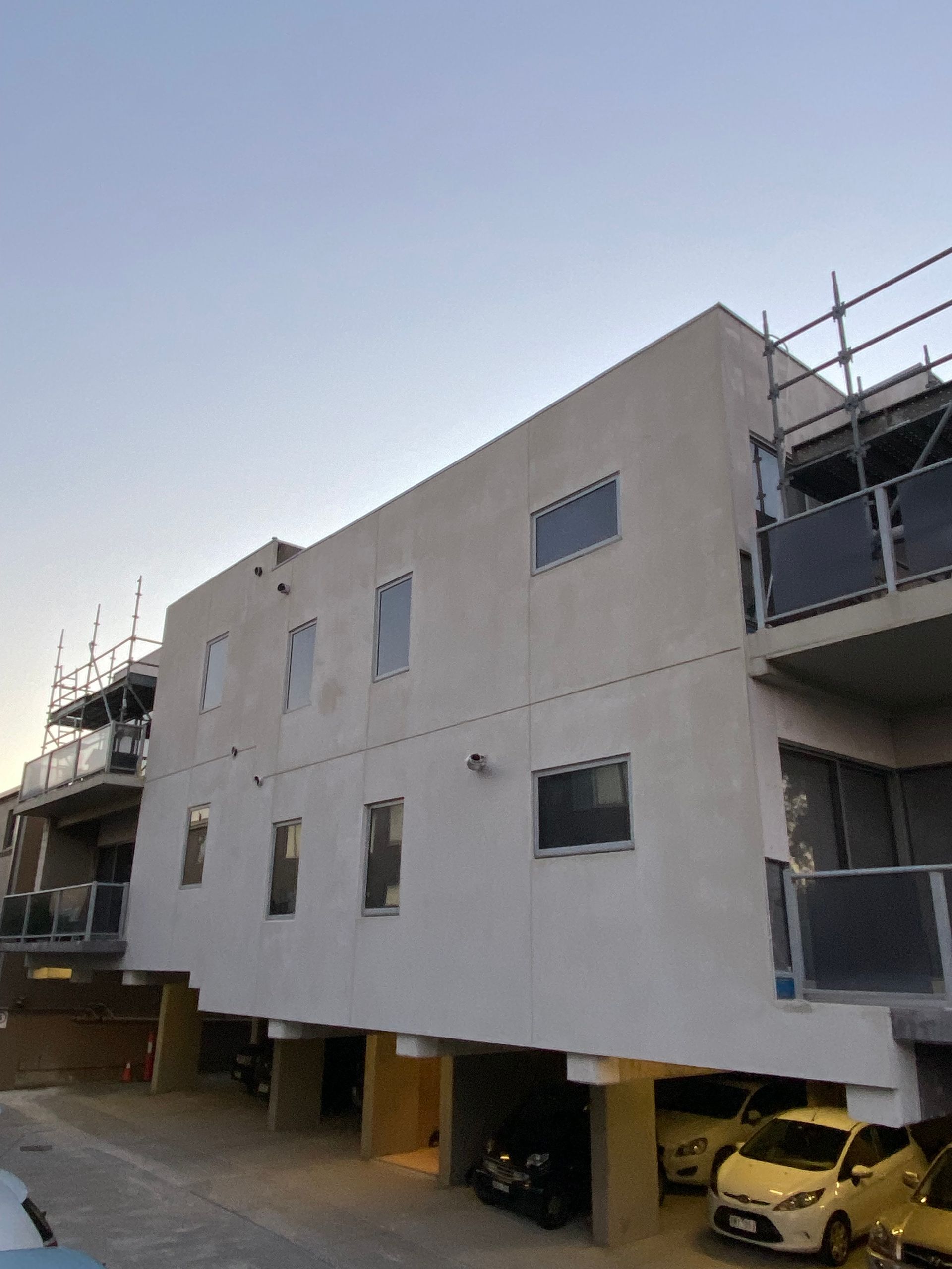 A white building with cars parked in front of it
