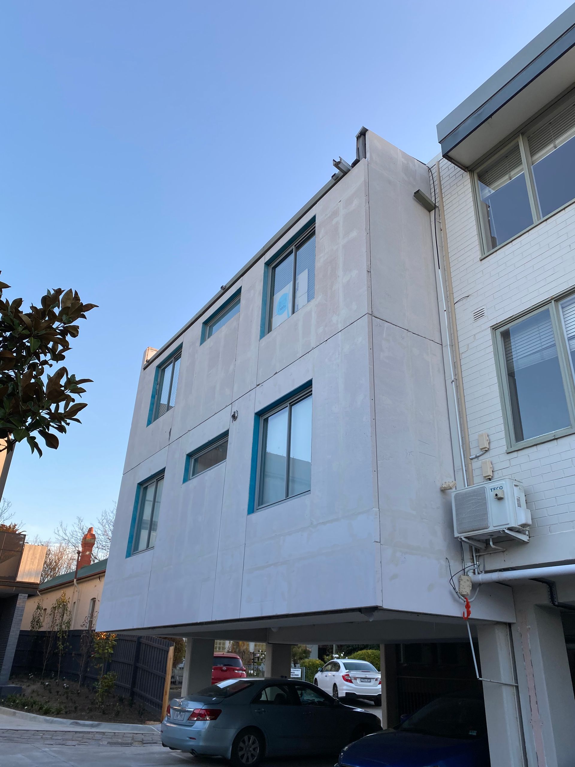 A building with a lot of windows and cars parked in front of it
