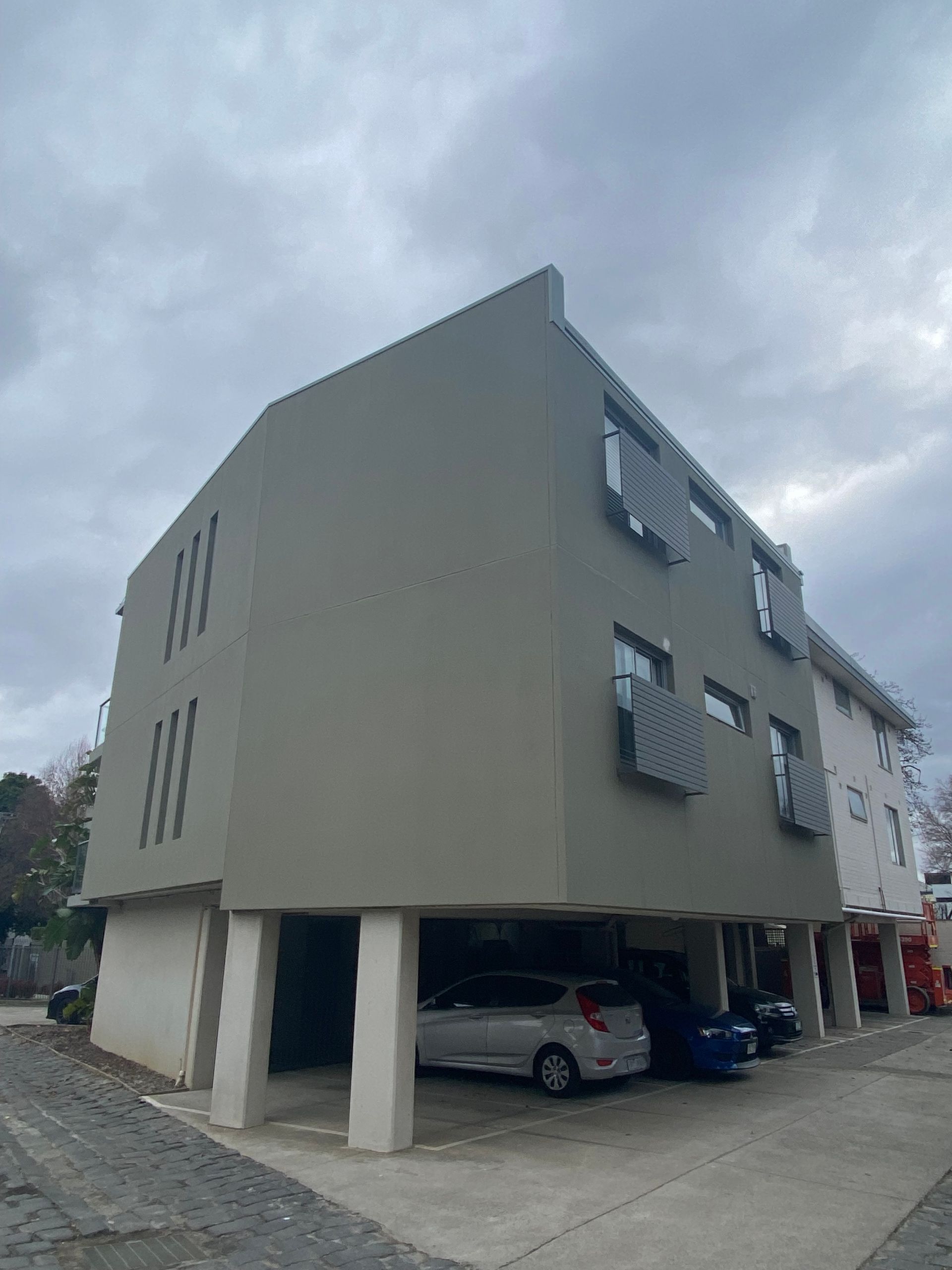 A large building with cars parked underneath it