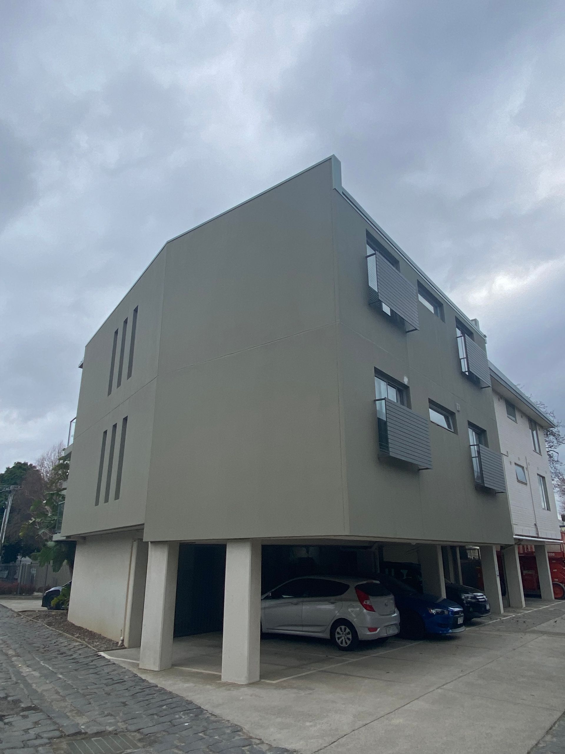 A white car is parked in front of a building