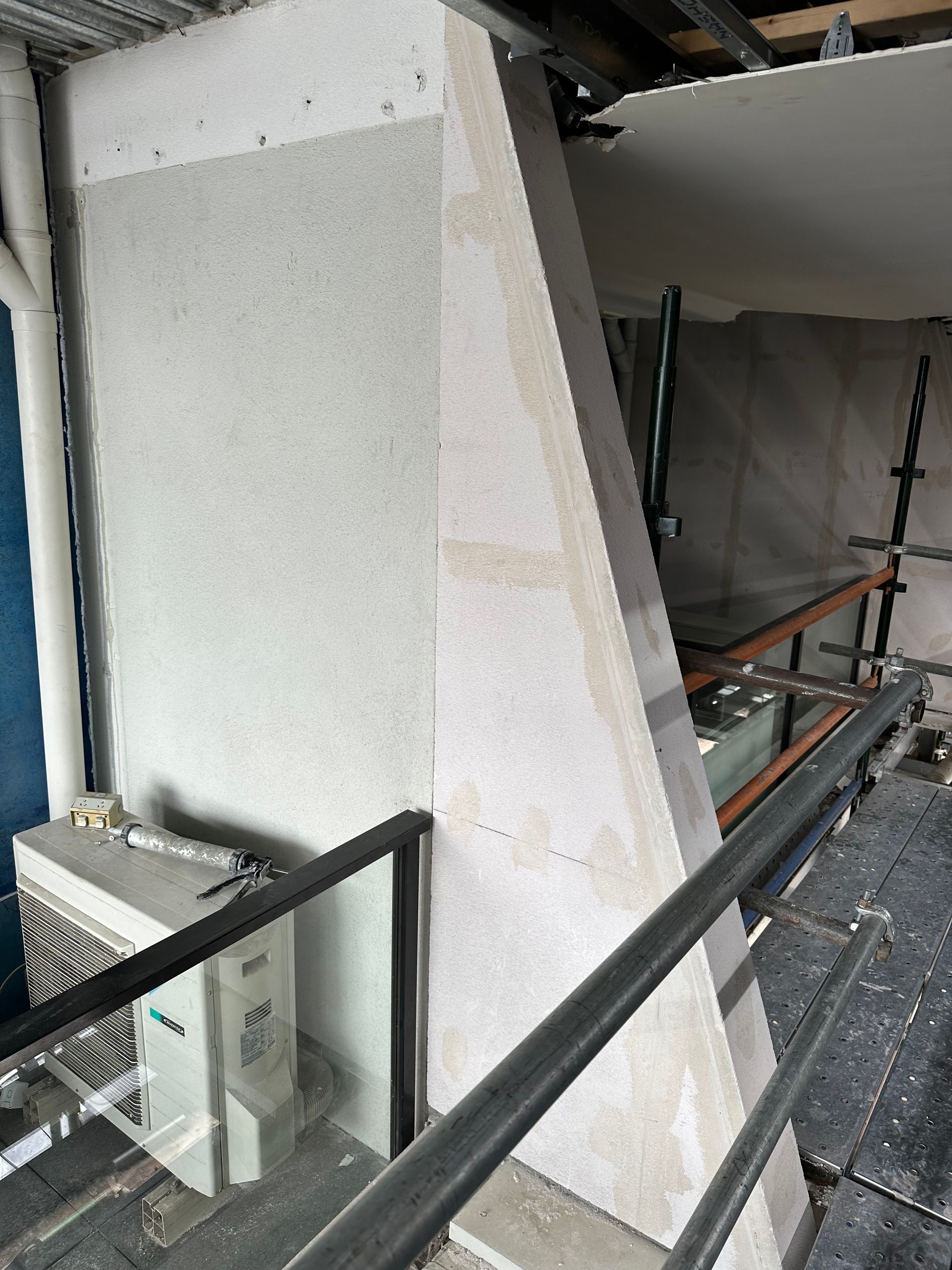 A building under construction with a staircase and a balcony.