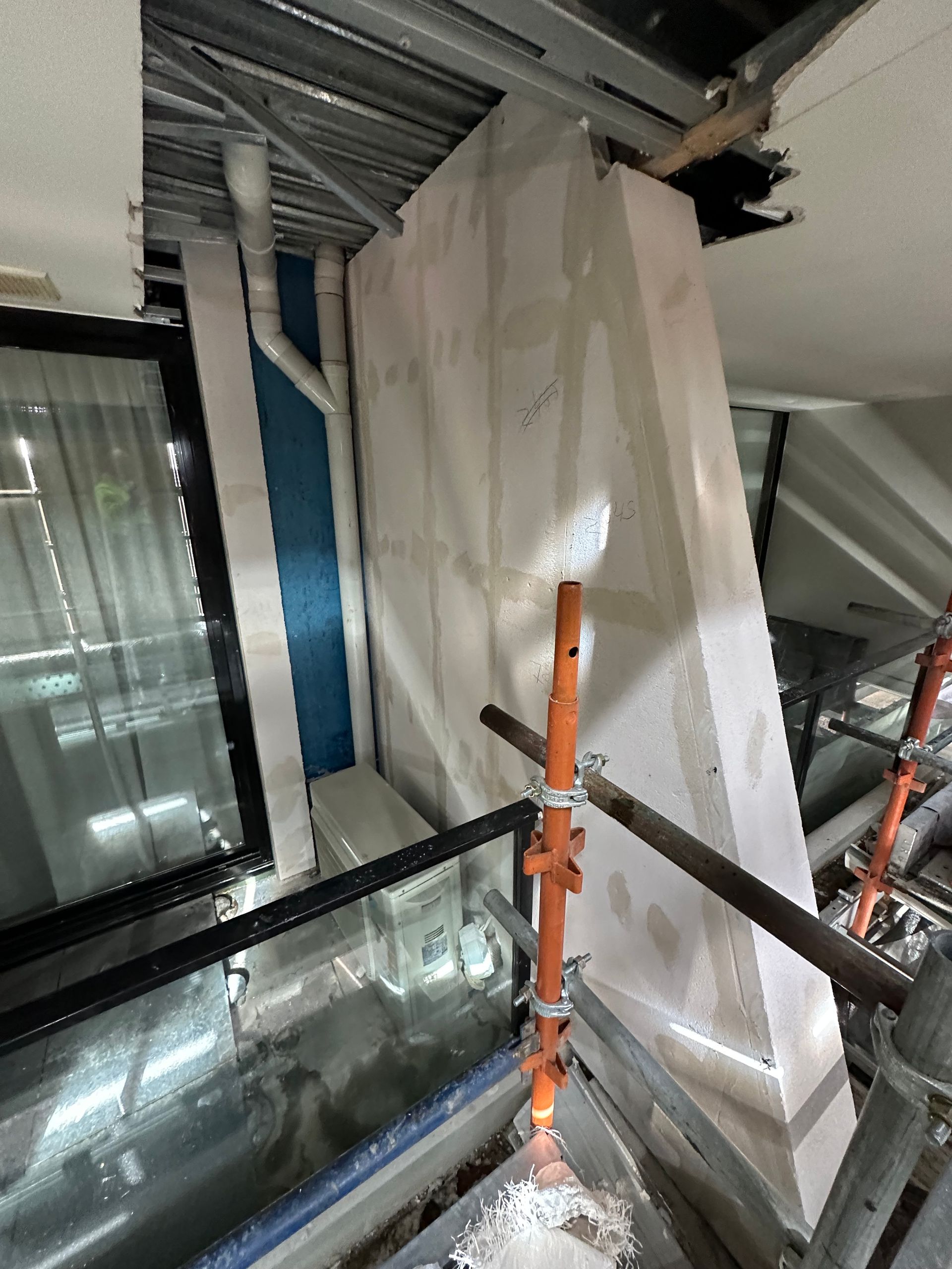 A building under construction with scaffolding and a window