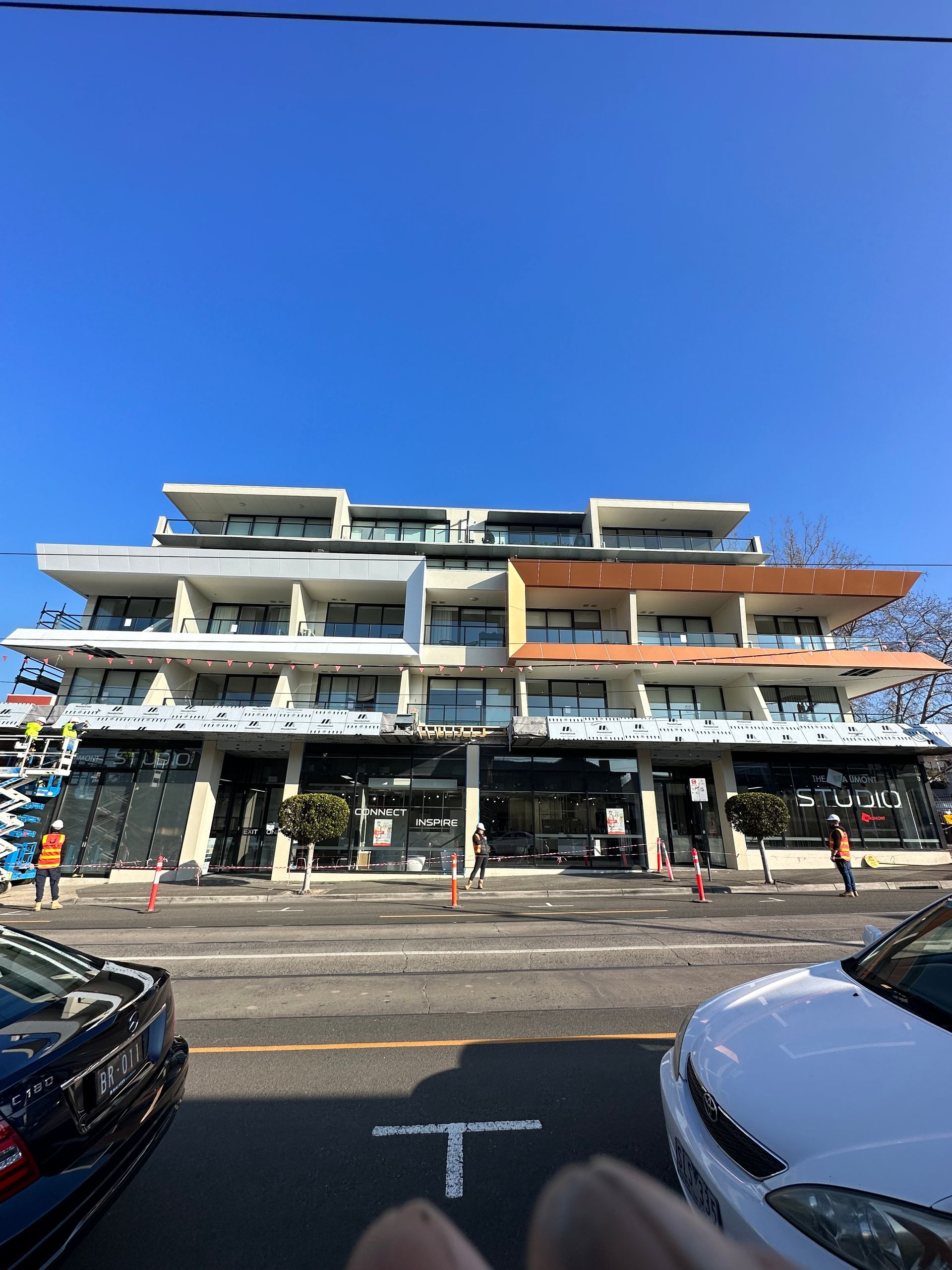 A white car is parked in front of a building that says total
