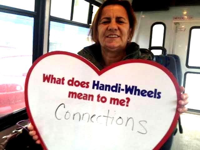 A female holding a heart with these written words: What does Handi-Wheels mean to me? Connections