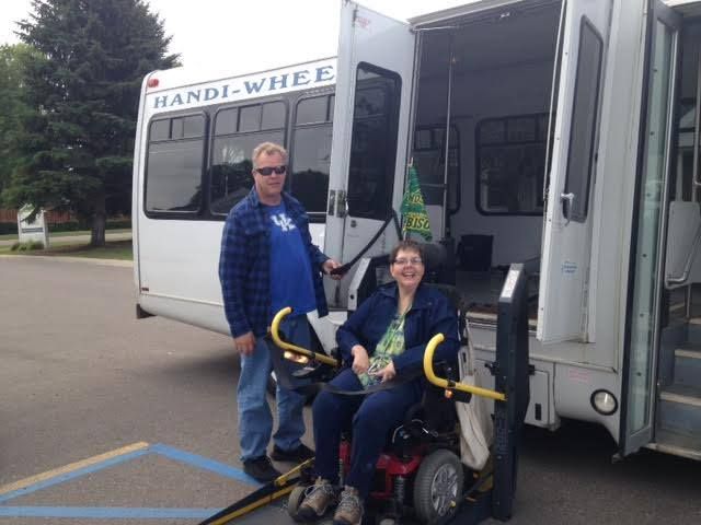 Deanna Bakken in her wheelchair on a Handi-Wheels bus wheelchair lift.