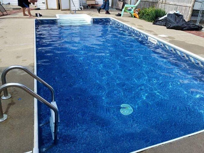 A large blue swimming pool with stairs leading to it
