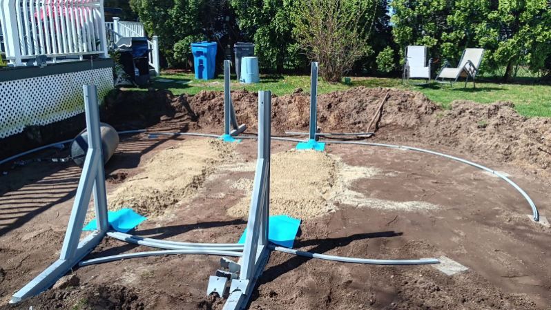 A swimming pool is being built in a backyard.