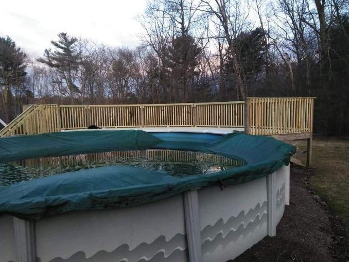 A swimming pool with a green cover and a wooden deck.