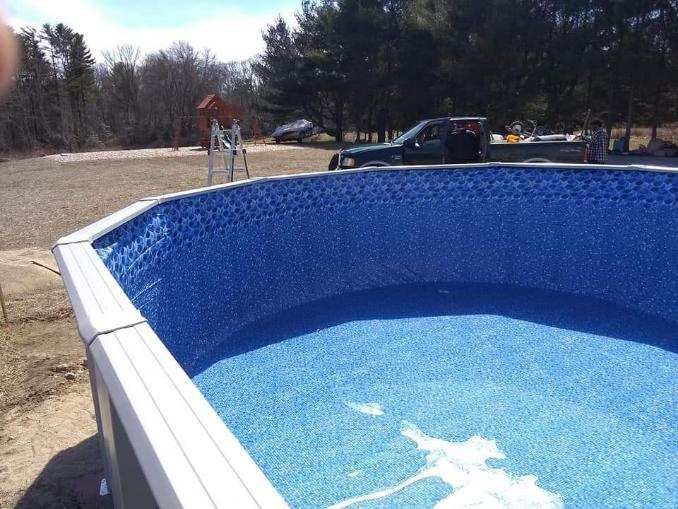 A swimming pool is being built in the middle of a dirt field.