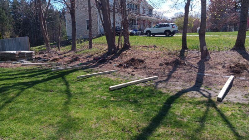 A car is parked in the grass in front of a house.