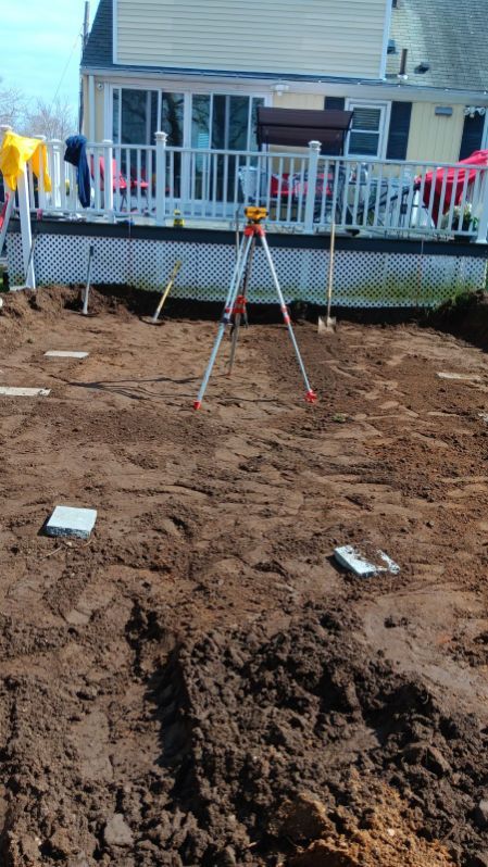 A tripod is sitting in the dirt in front of a house.