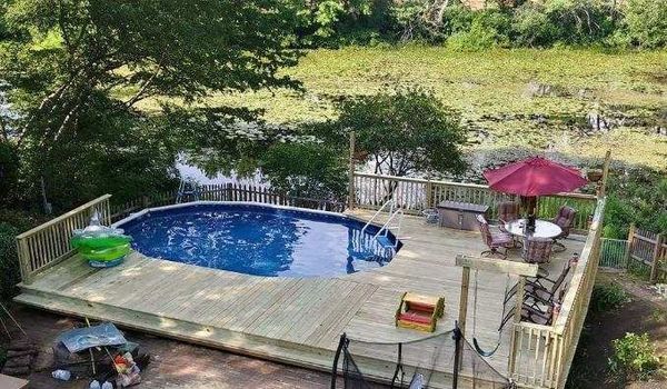 A large swimming pool is surrounded by a wooden deck.