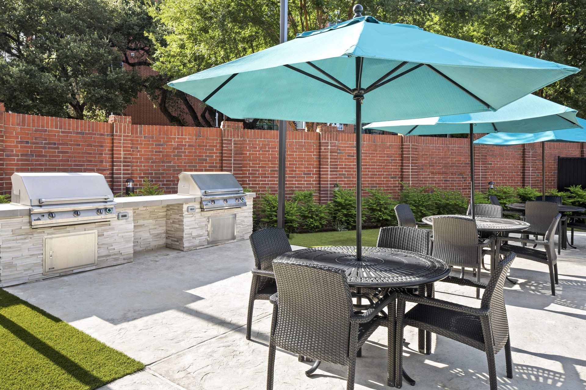 Outdoor dining area with umbrellas and grills at Marquis Enclave, offers apartments near downtown Houston, TX.