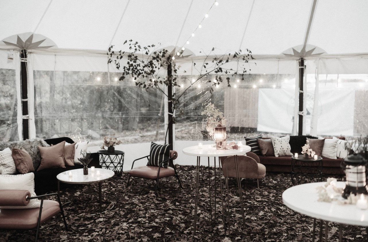 A bride in a white dress is standing next to a white trailer.