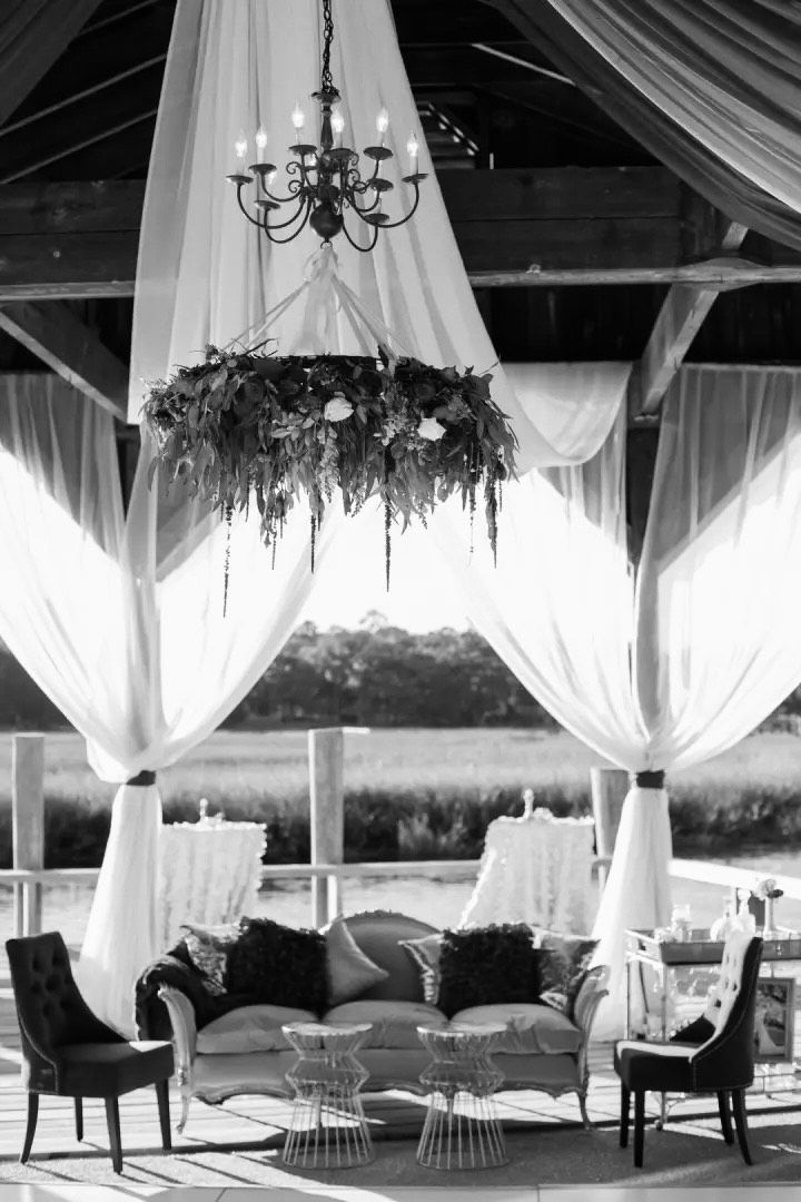 A bride and groom are holding hands in front of a white house.