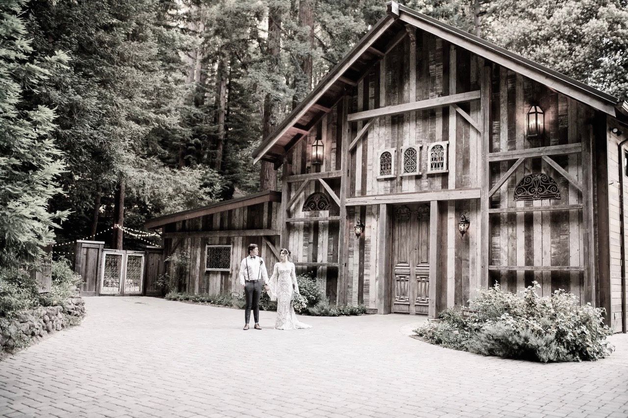 A neon sign that says will you marry me is surrounded by flowers and candles.