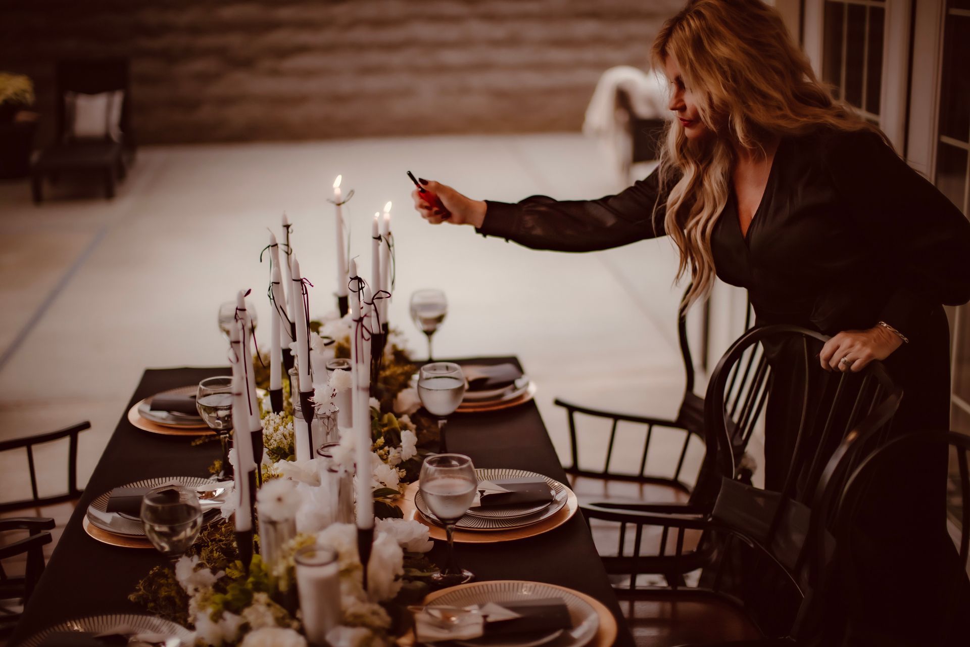 A bride and groom are standing in front of a barn holding hands.