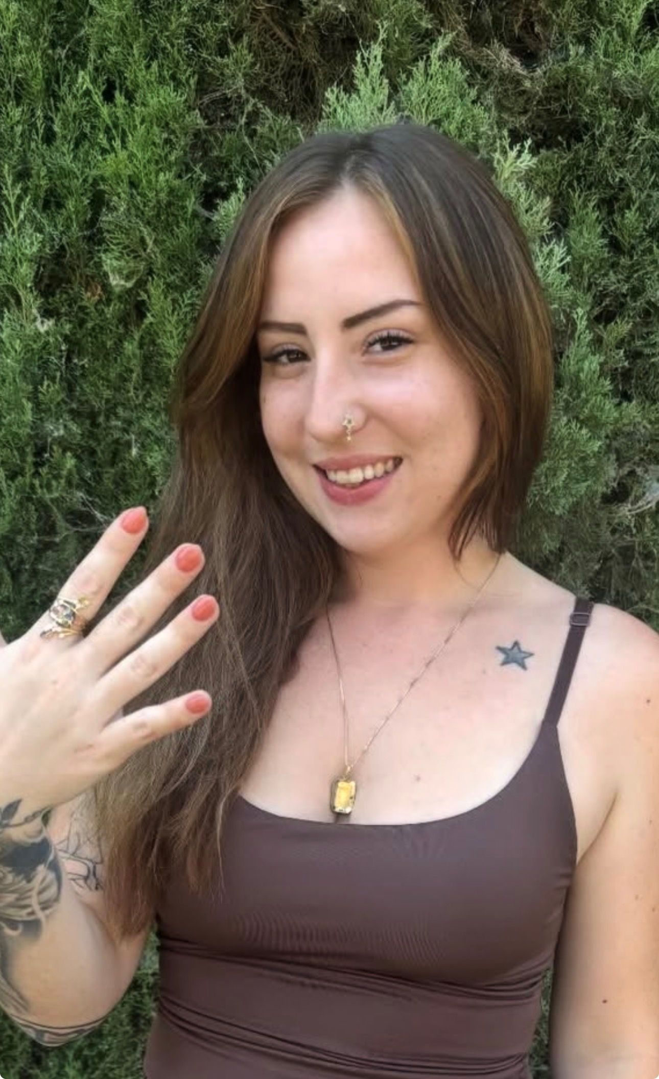 A woman with red hair is smiling while sitting in a car.