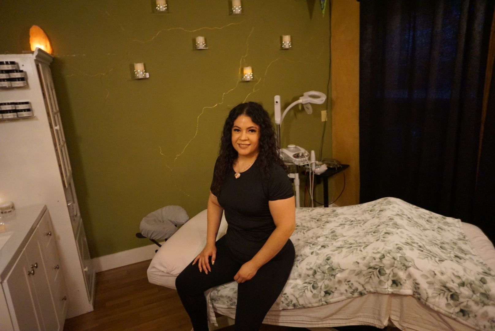 A woman wearing sunglasses and a flower in her hair is standing on a beach.