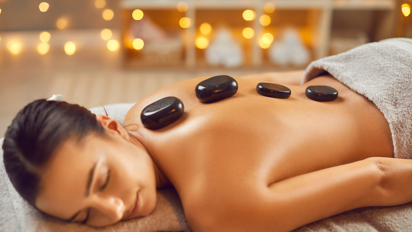 A woman is getting a hot stone massage at a spa.