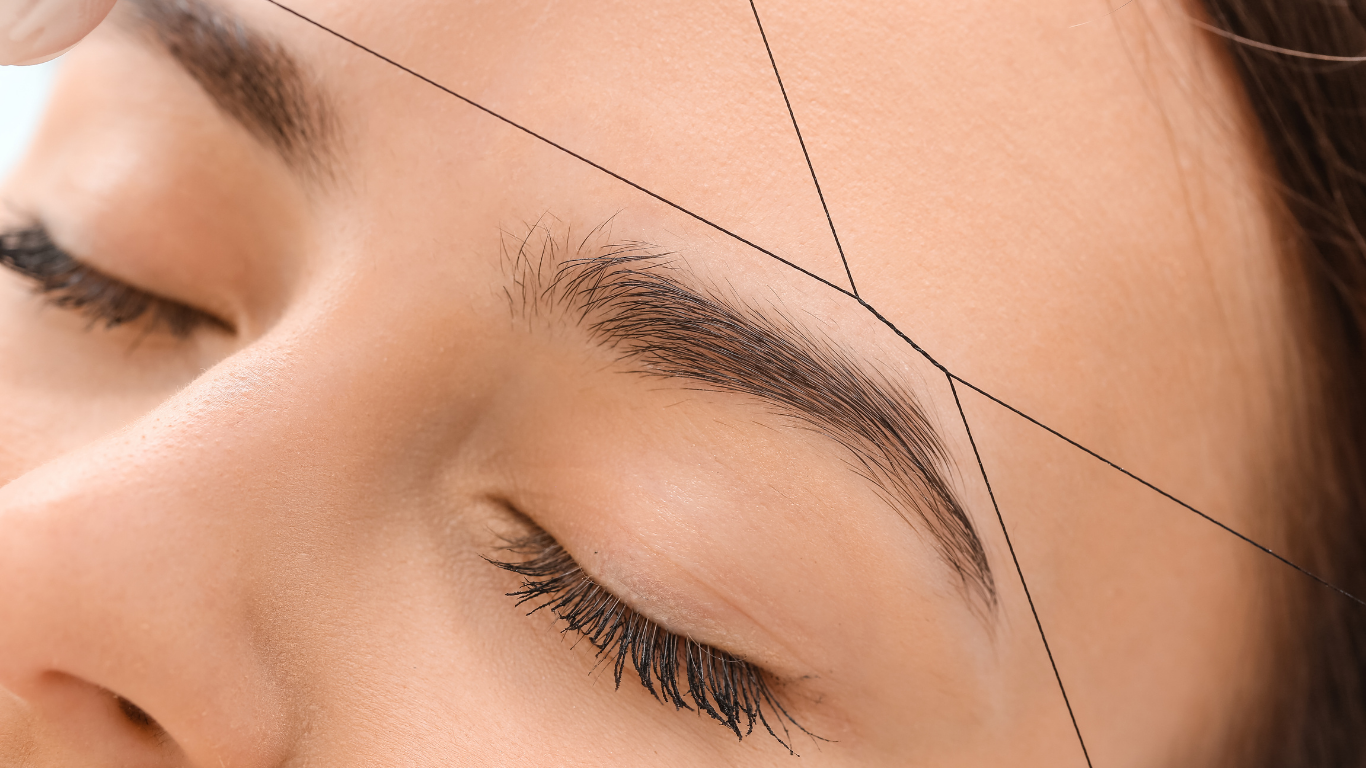 A close up of a woman 's face with a drawing of her eyebrows.