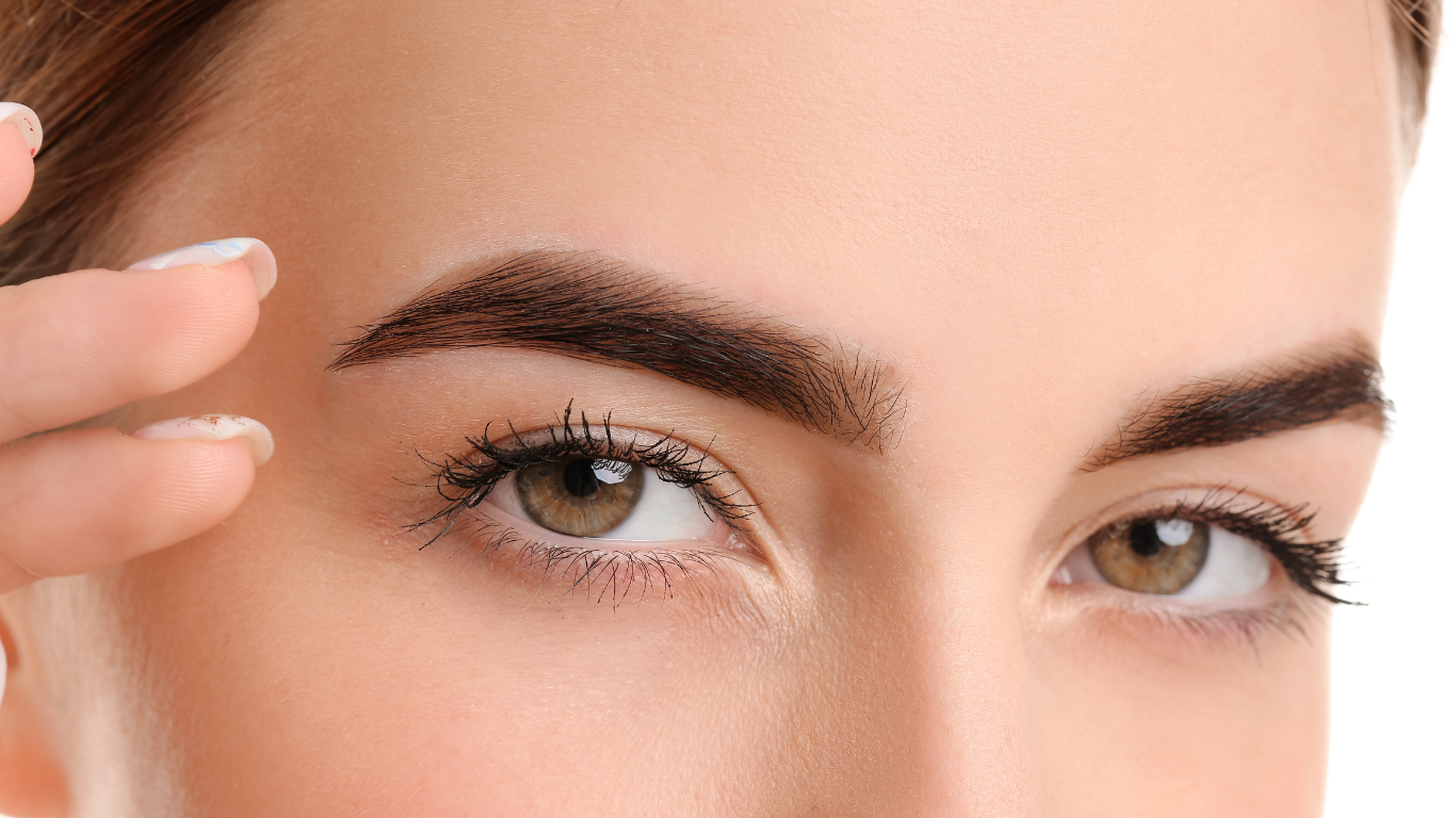 A close up of a woman 's eye and eyebrows on a white background.
