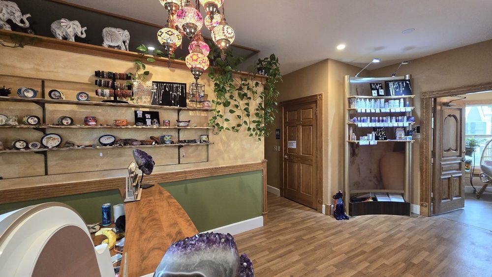 A room with a wooden floor , shelves , and a chandelier.