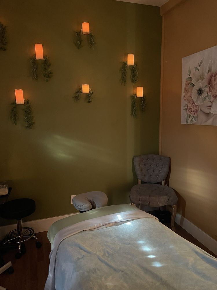 A massage table in a room with candles on the wall