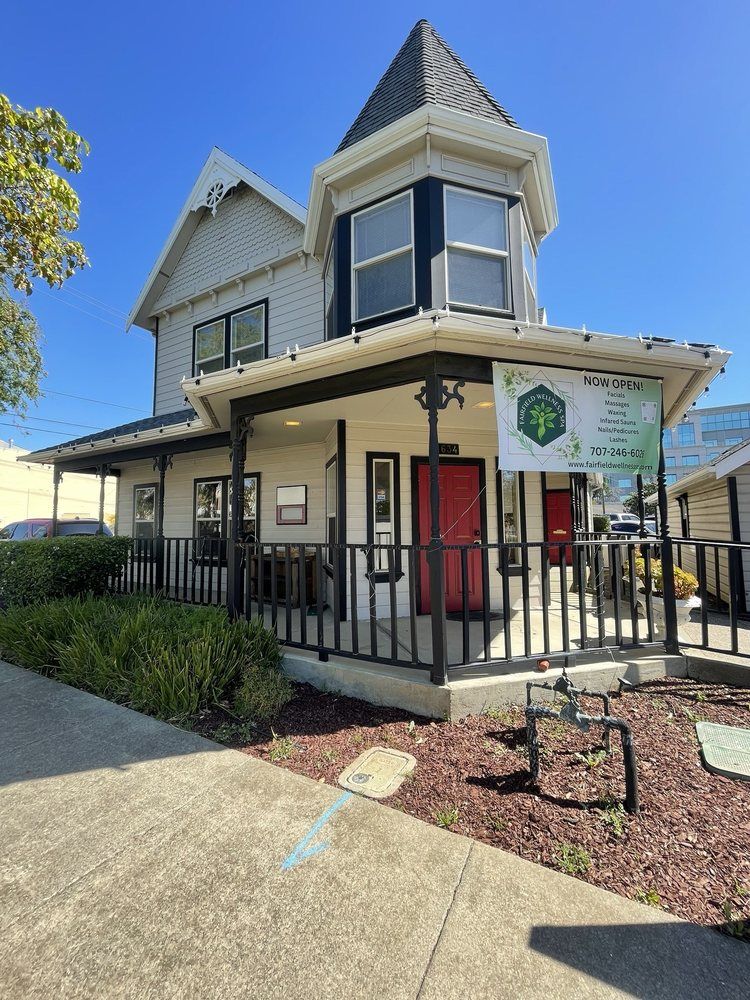 A large white house with a red door and a porch.