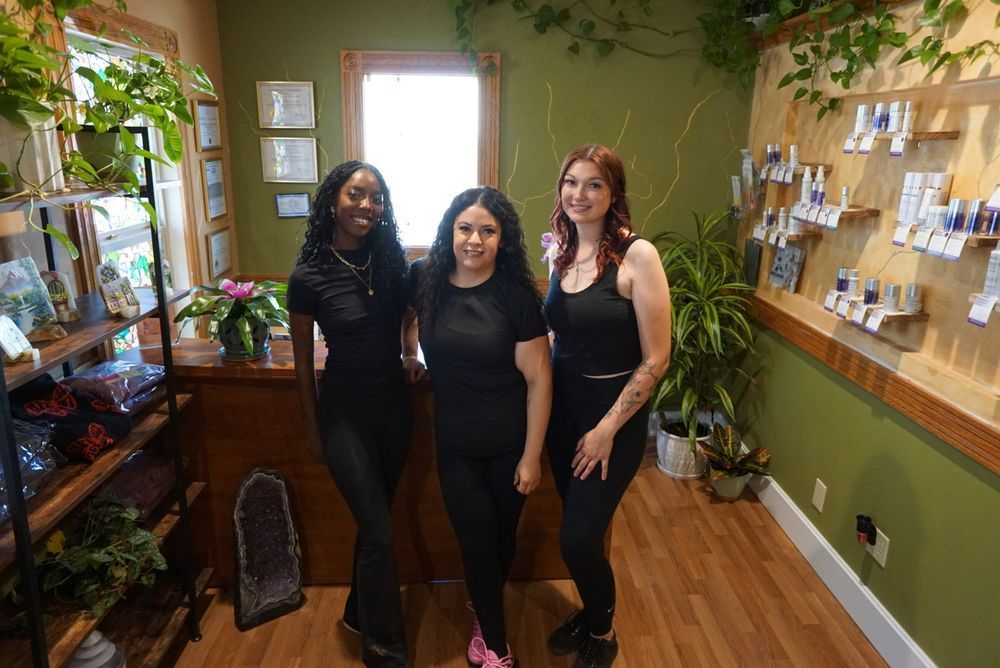 Three women are standing next to each other in a room.