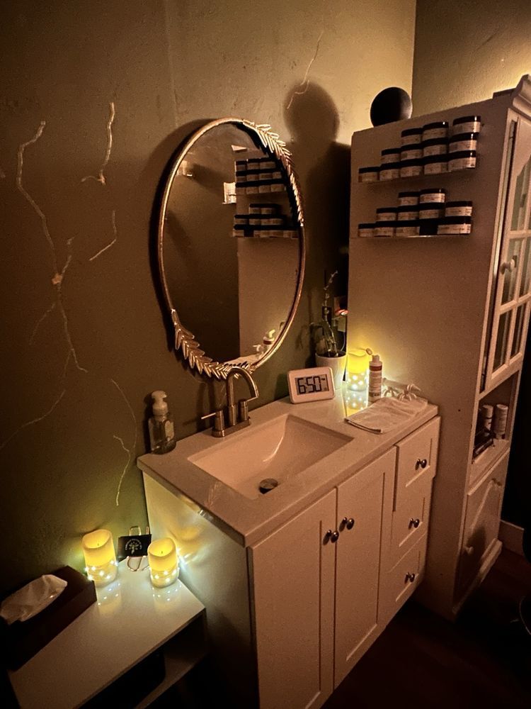 A bathroom with a sink , mirror and candles