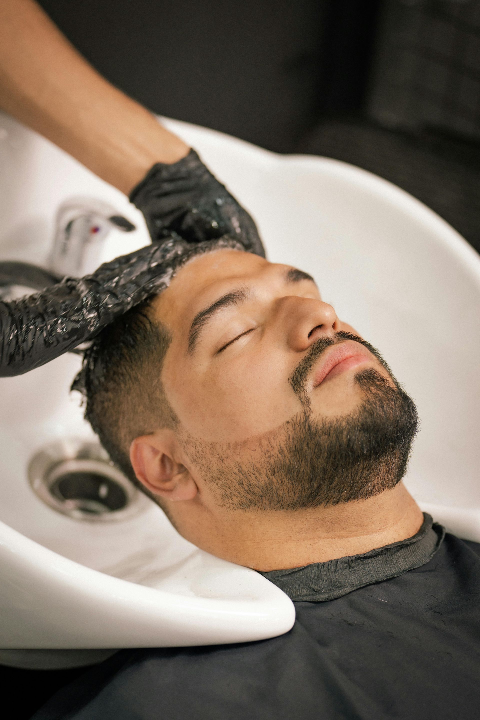 A man is getting his hair washed at a salon.