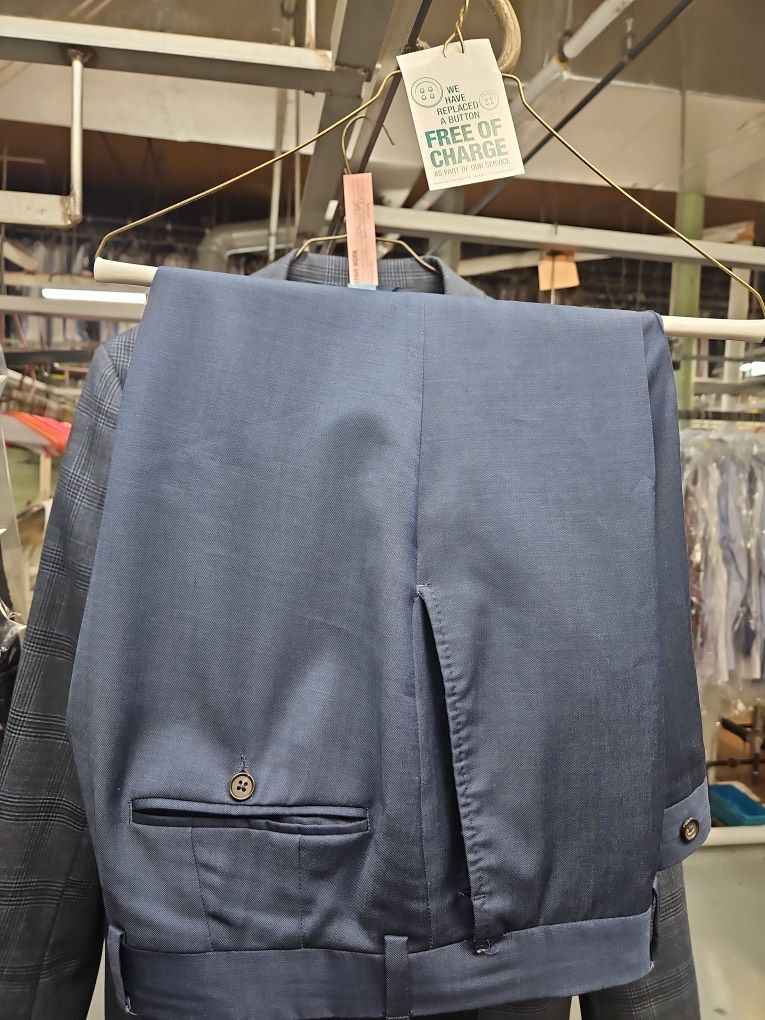 A pair of blue pants is hanging on a hanger in a laundromat.