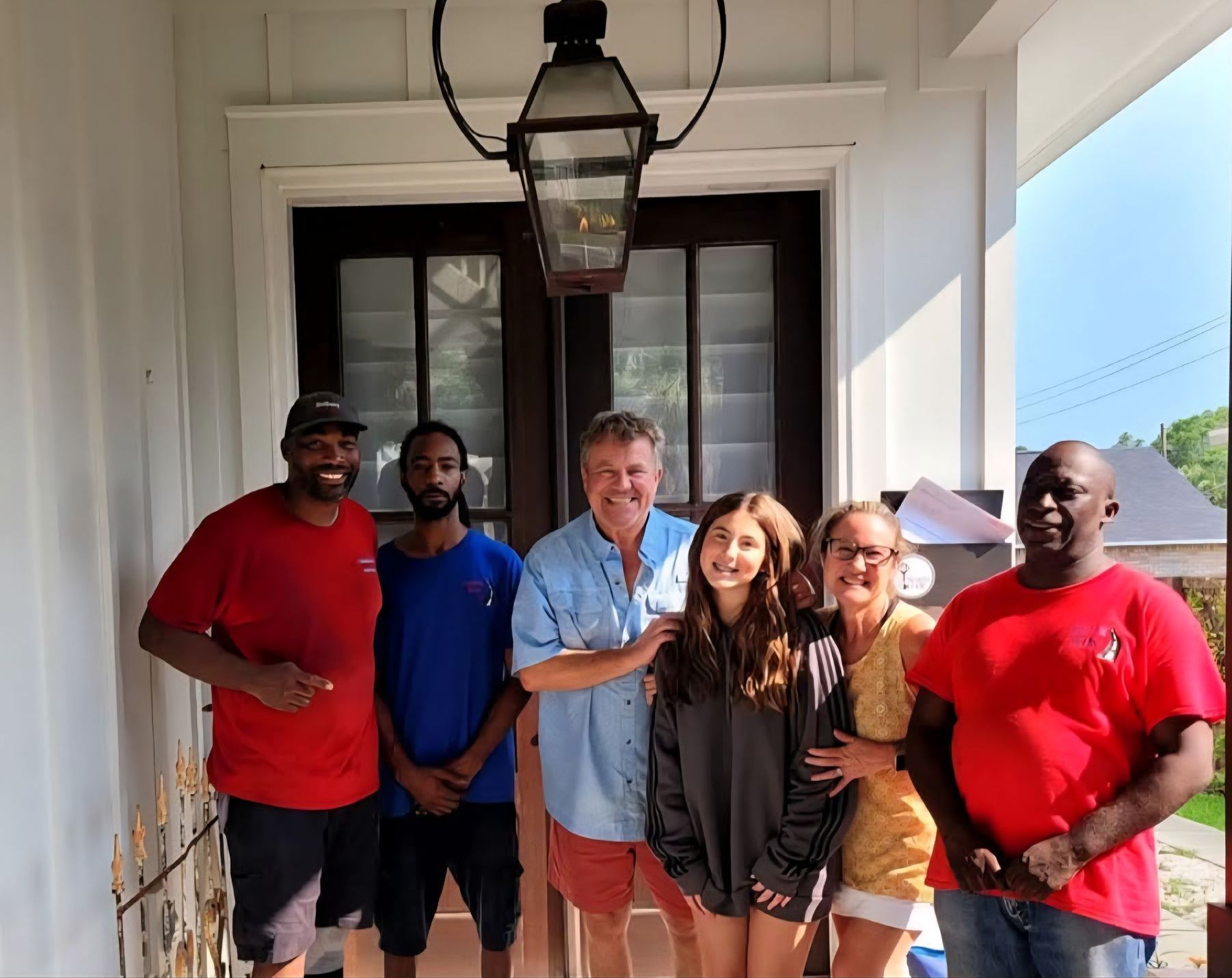 A group of people are posing for a picture in front of a door.