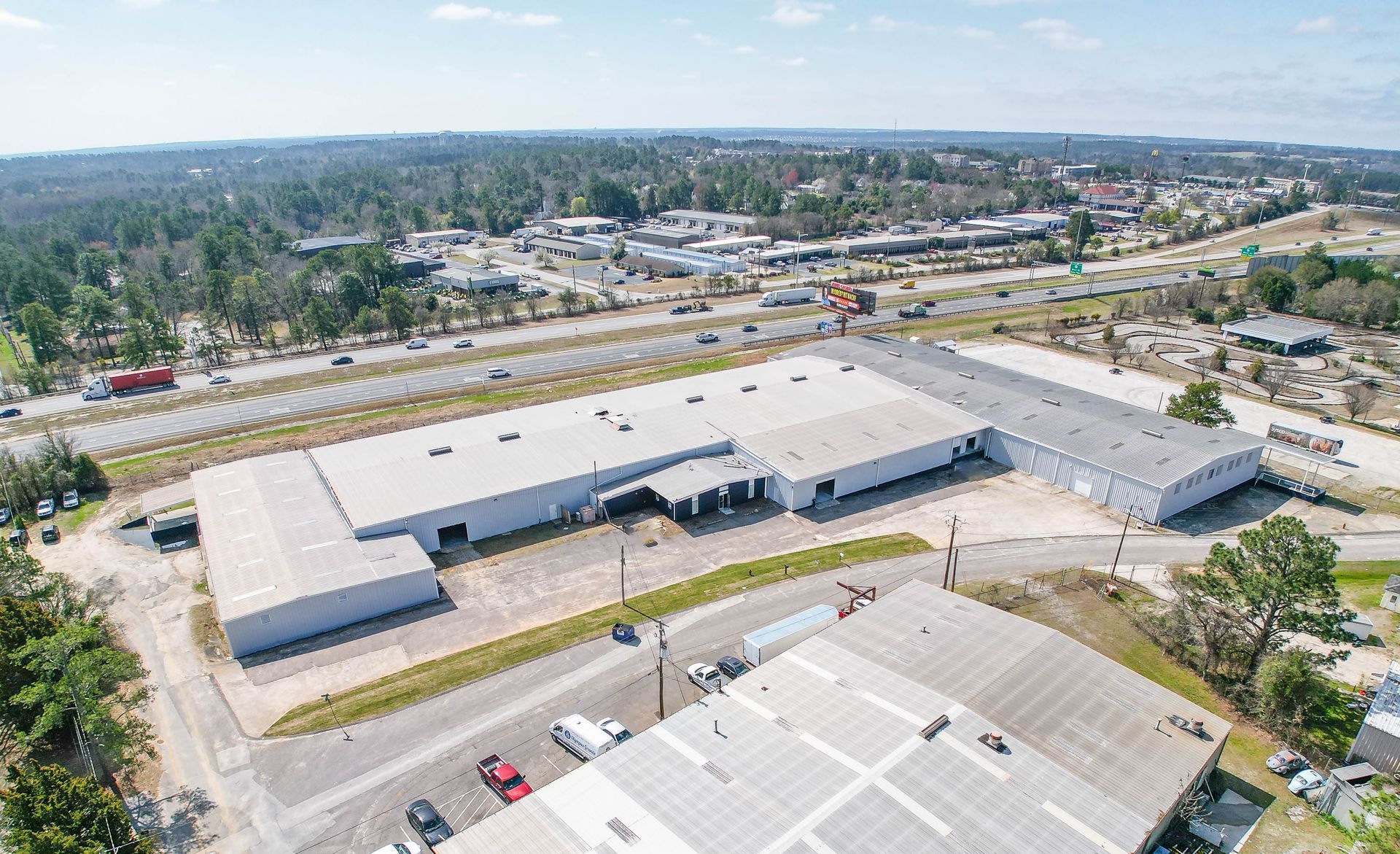 Aerial view of large industrial building along a major highway