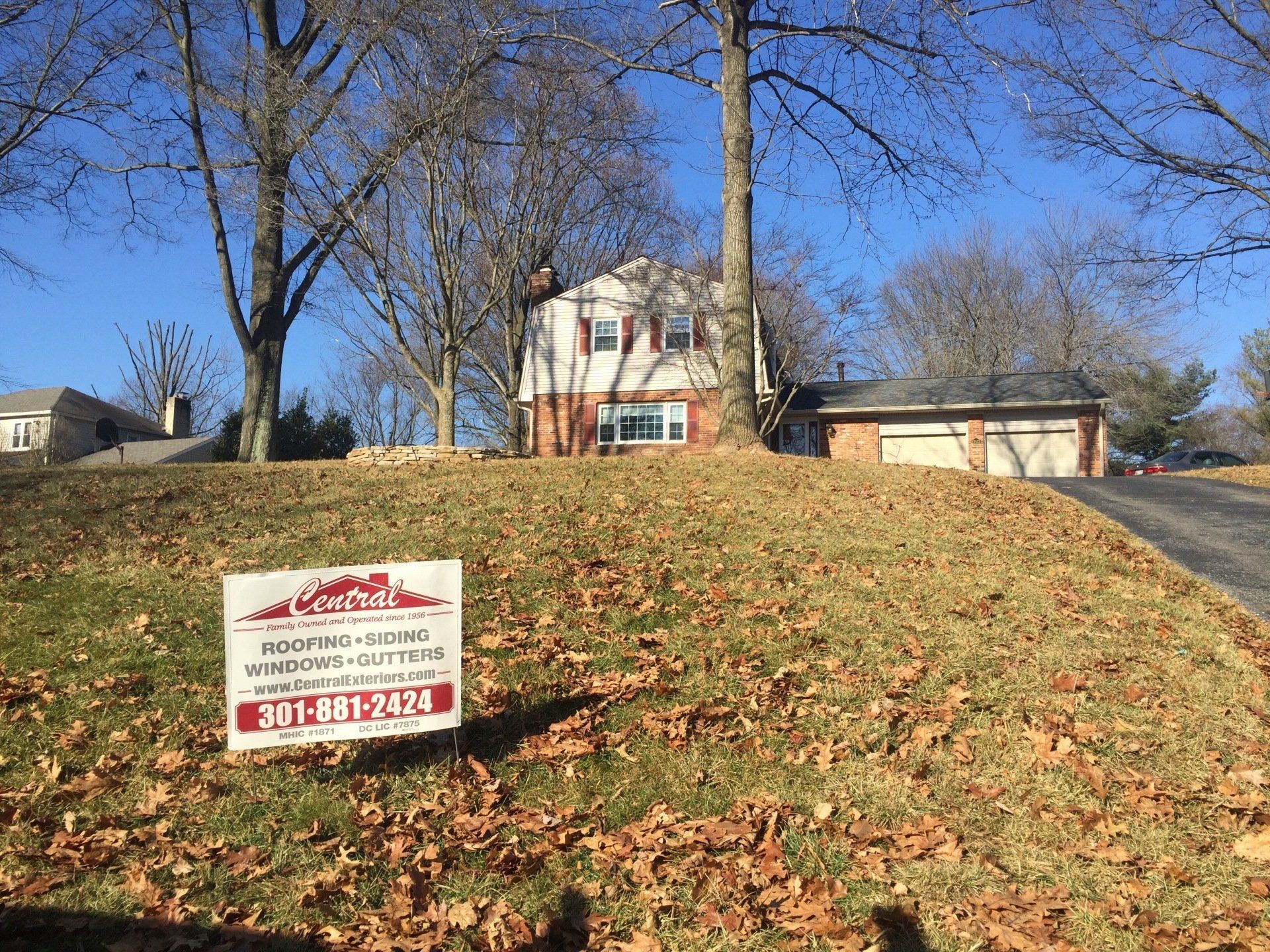 A house with a for sale sign in front of it.