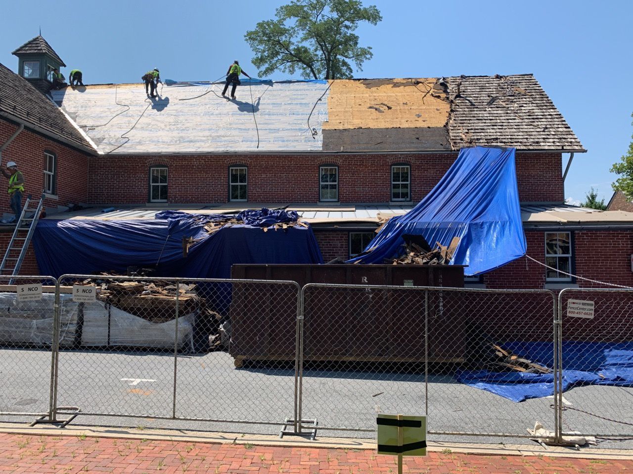 A blue tarp is covering the roof of a building