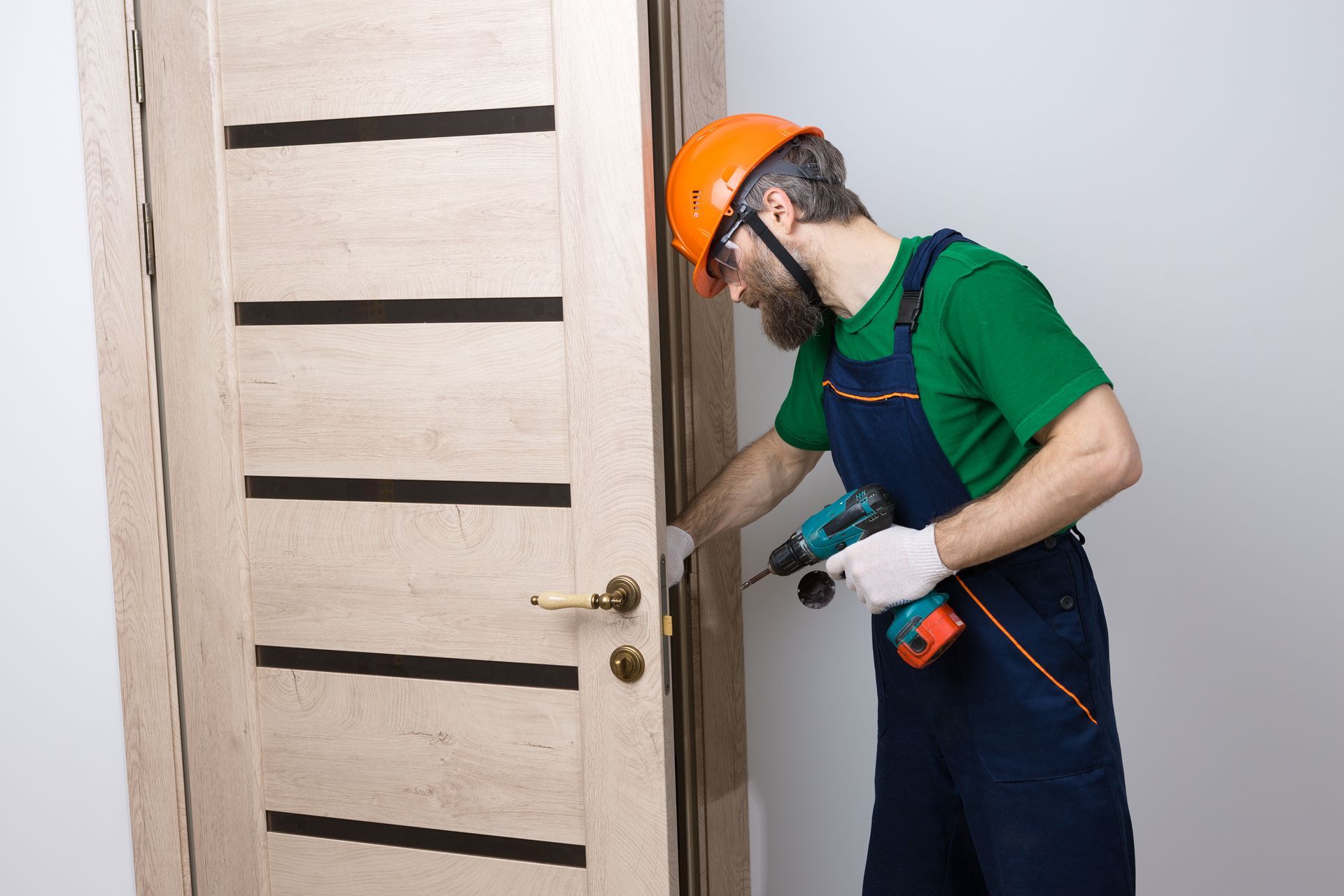 A man is installing a door with a drill.