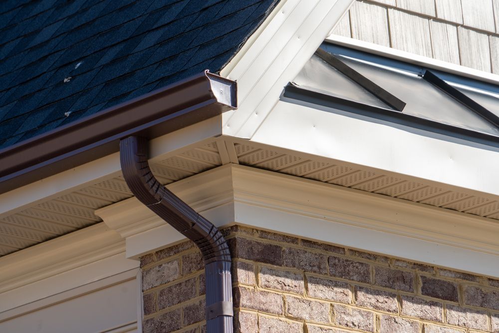 A close up of a gutter on the side of a house.