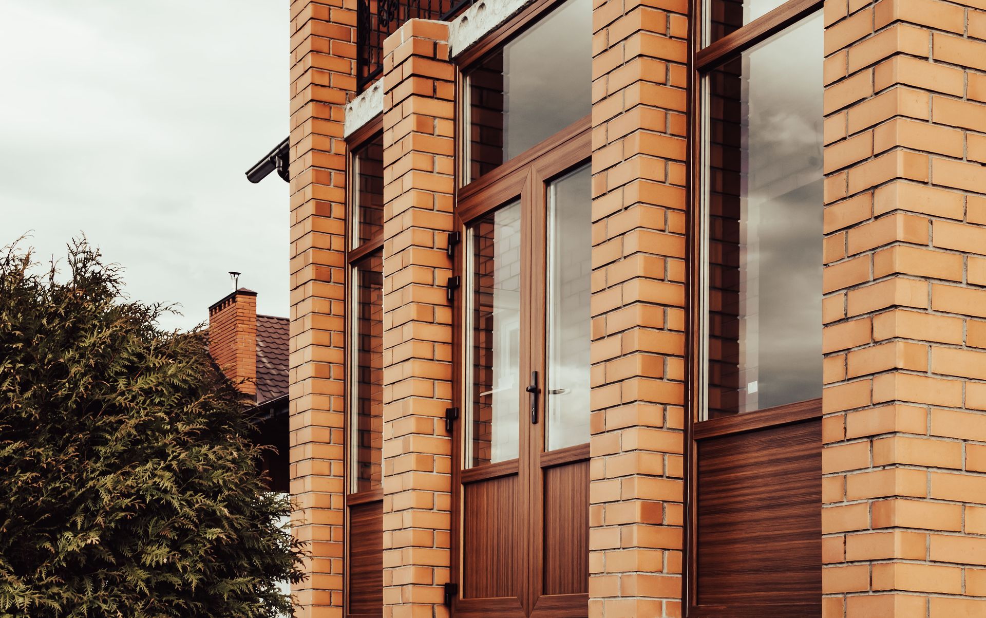 A brick building with a wooden door and columns.